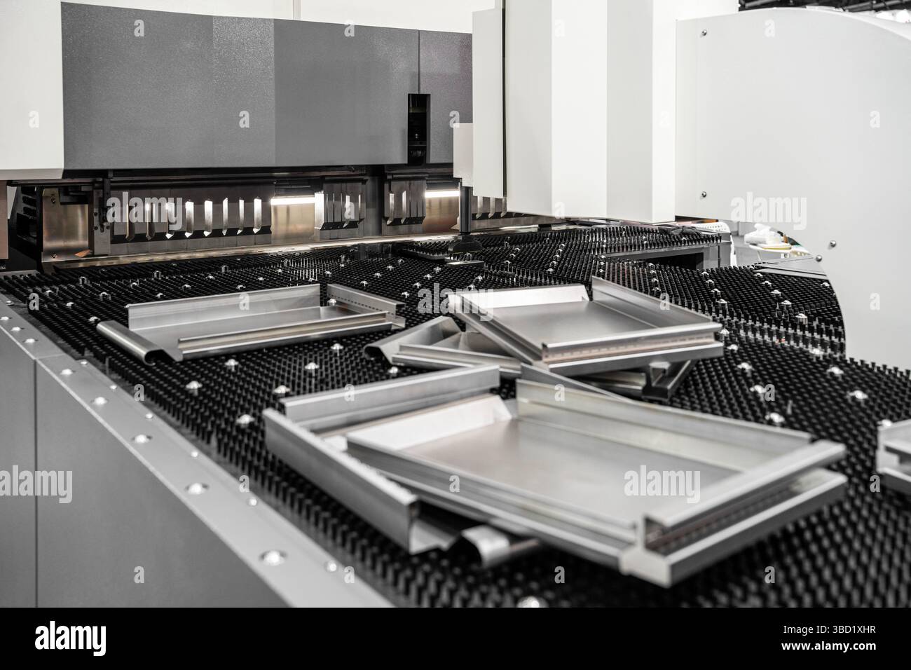Automatic metal sheet bending machine at work in factory. CNC Panel Bender (Press Arm Type) Stock Photo