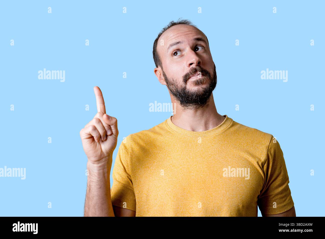 young man pointing finger up to copy space, having an idea Stock Photo