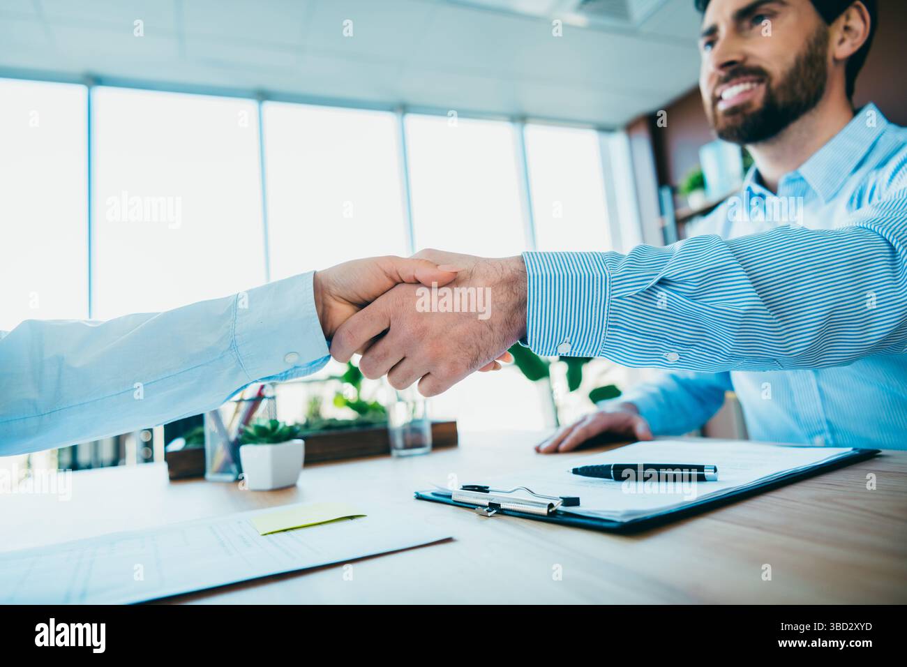 Professional handshake occurring between two colleagues in an office ...