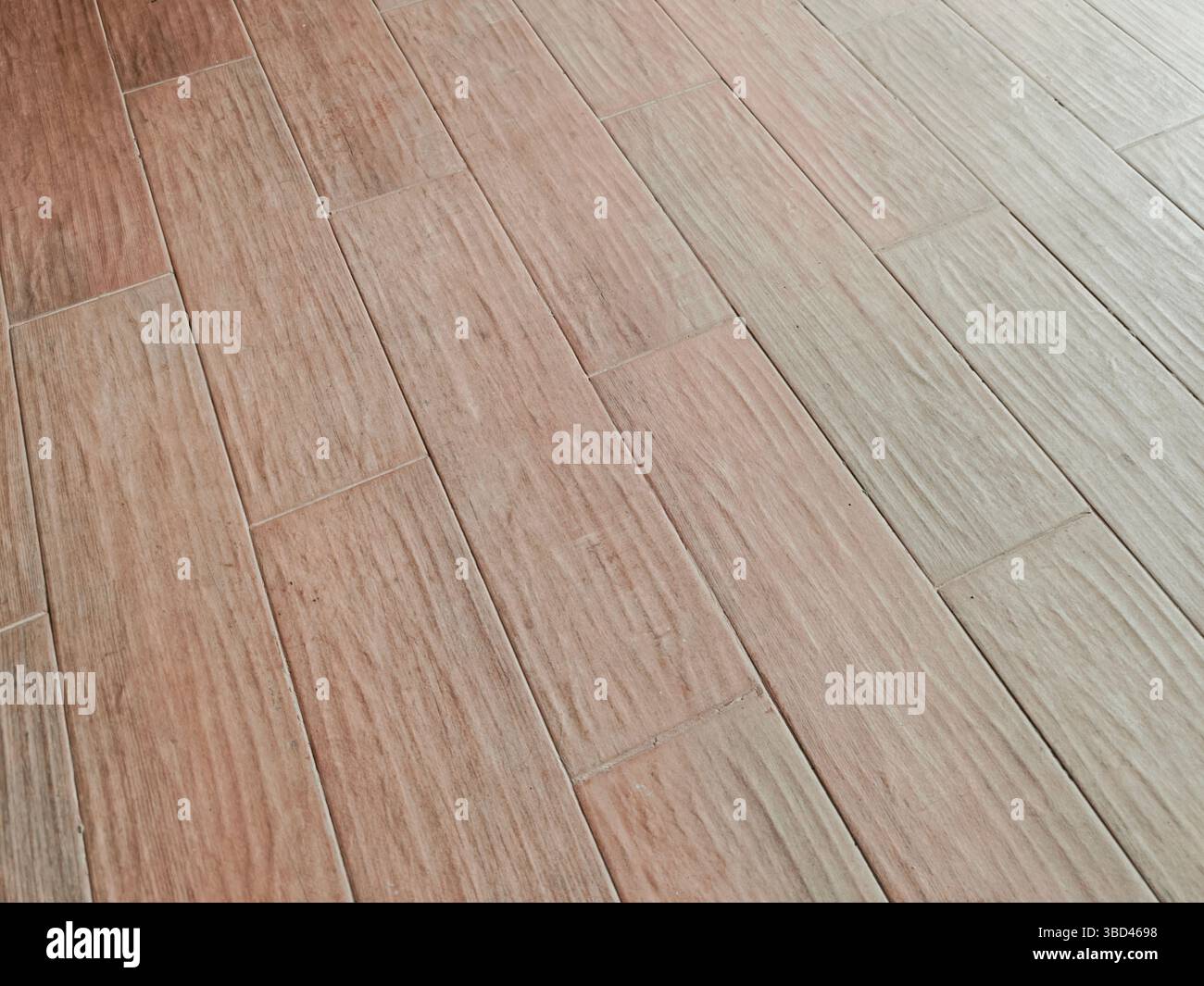 Light brown tiles arranged in a staggered pattern, creating a modern and stylish floor surface Stock Photo