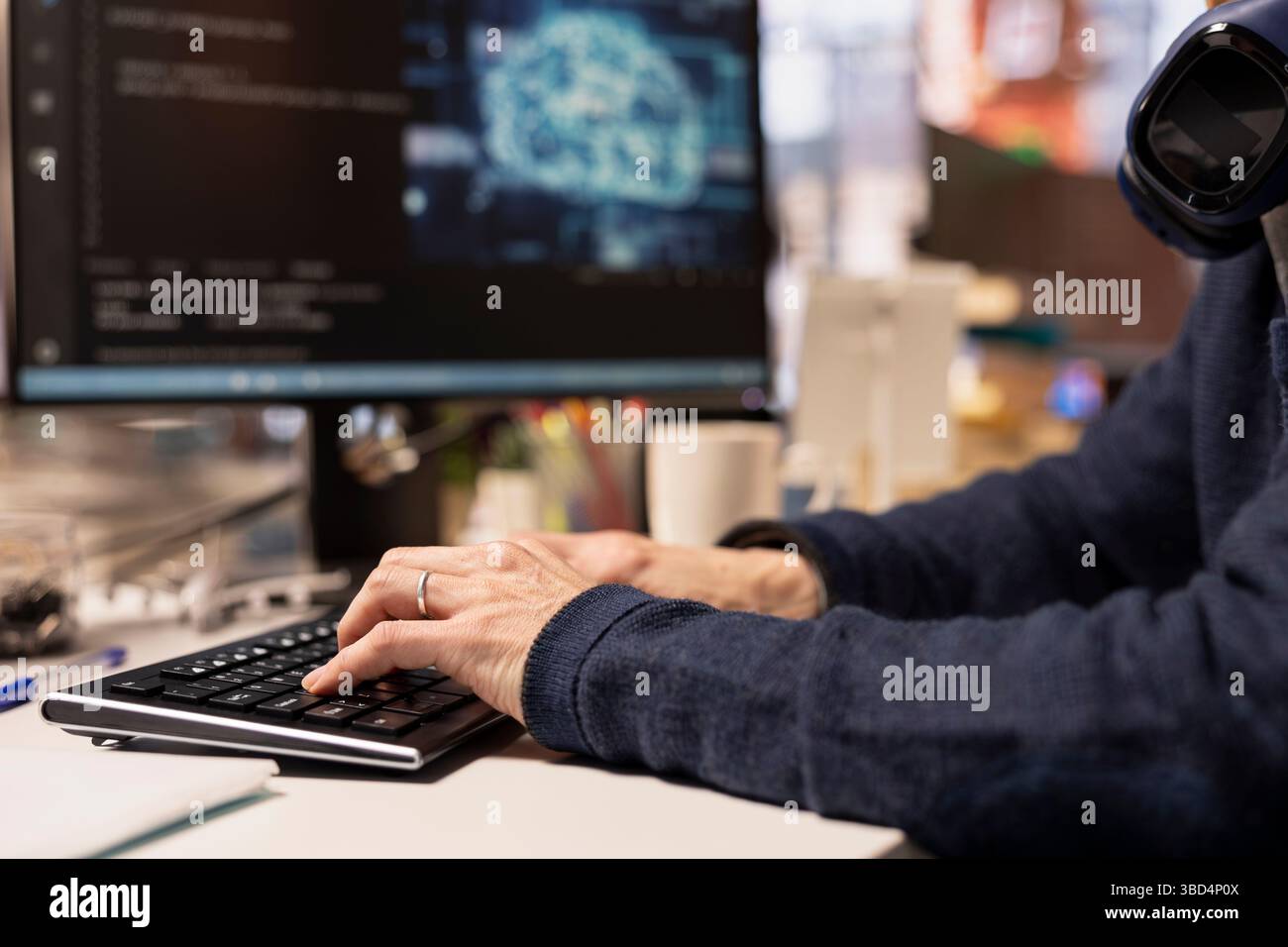 Software engineer in startup company office using computer to oversee artificial intelligence neural networks. Close up of IT professional using AI machine learning systems on PC Stock Photo