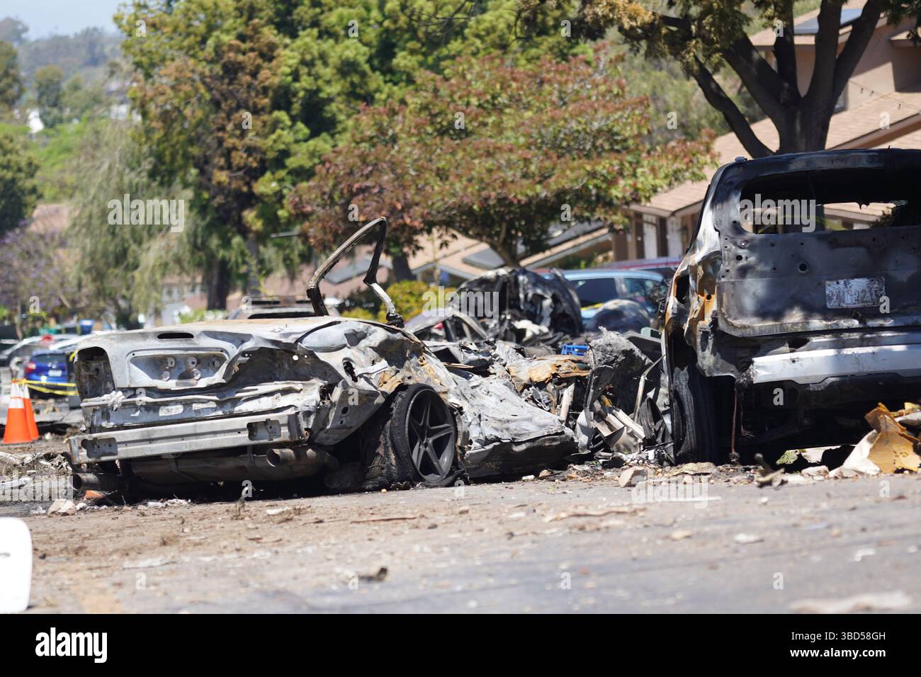San Diego, United States. 22nd May, 2025. Vehicles are destroyed by the plane crash. A Cessna 500 private jet crashed into San Diego's Murphy Canyon neighborhood early on May 22 while approaching Montgomery-Gibbs Executive Airport, killing at least two people. The crash sparked fires and destroyed several homes and vehicles. Federal investigators from the FAA and NTSB are on scene, and nearby residents have been ordered to evacuate as the investigation and cleanup continue. Credit: SOPA Images Limited/Alamy Live News Stock Photo