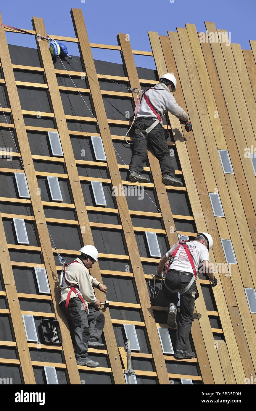 Workers With Ropes Construction workers protected by safety harnesses, hard hats and ropes ...