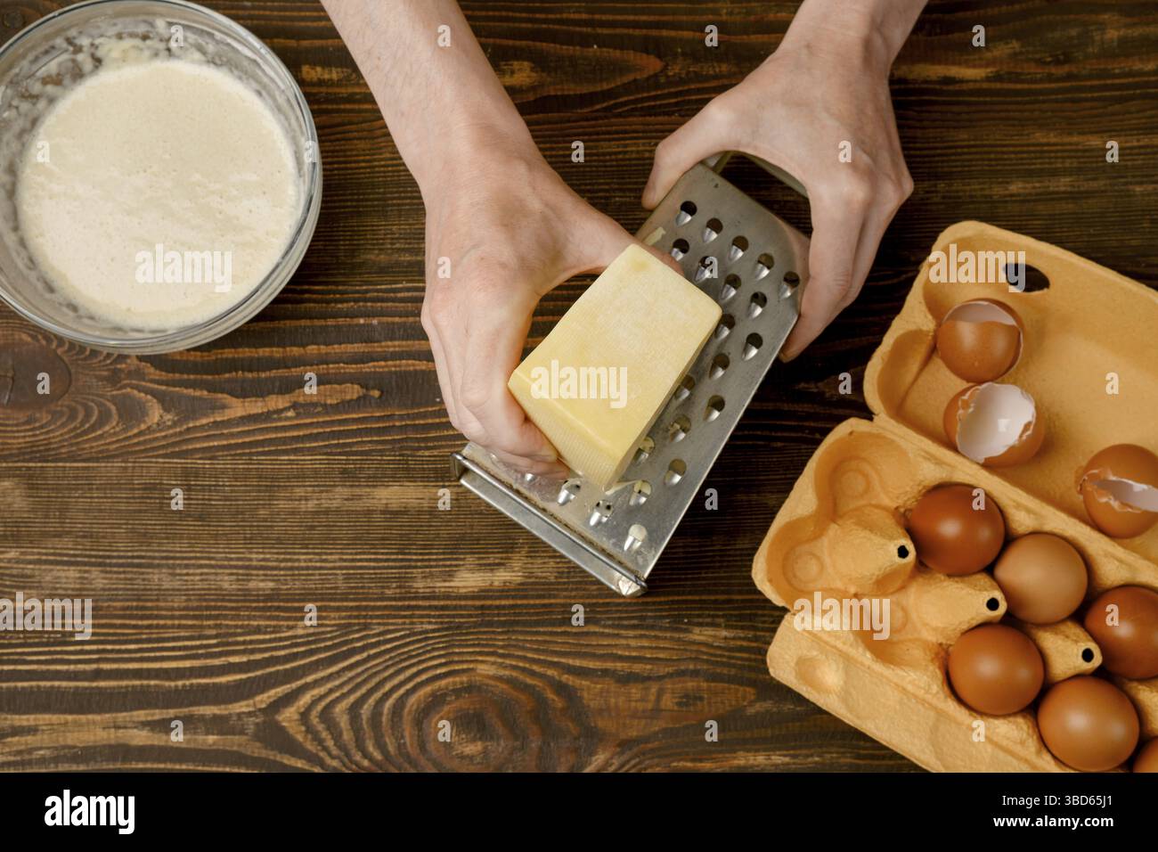 Male hands using grater for cheese, top view Stock Photo