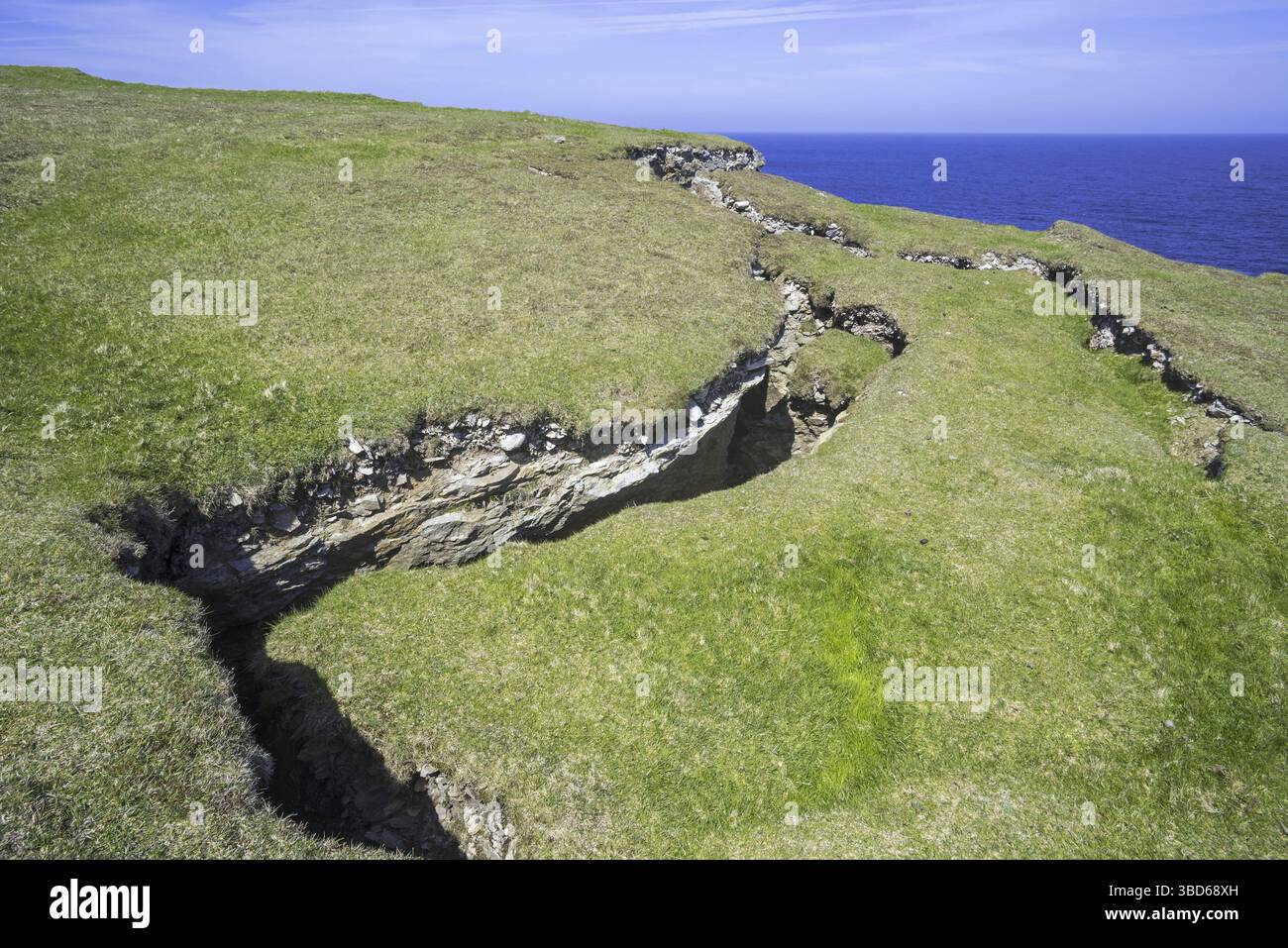Coastal erosion showing huge cracks, clefts in the rock on top of ...