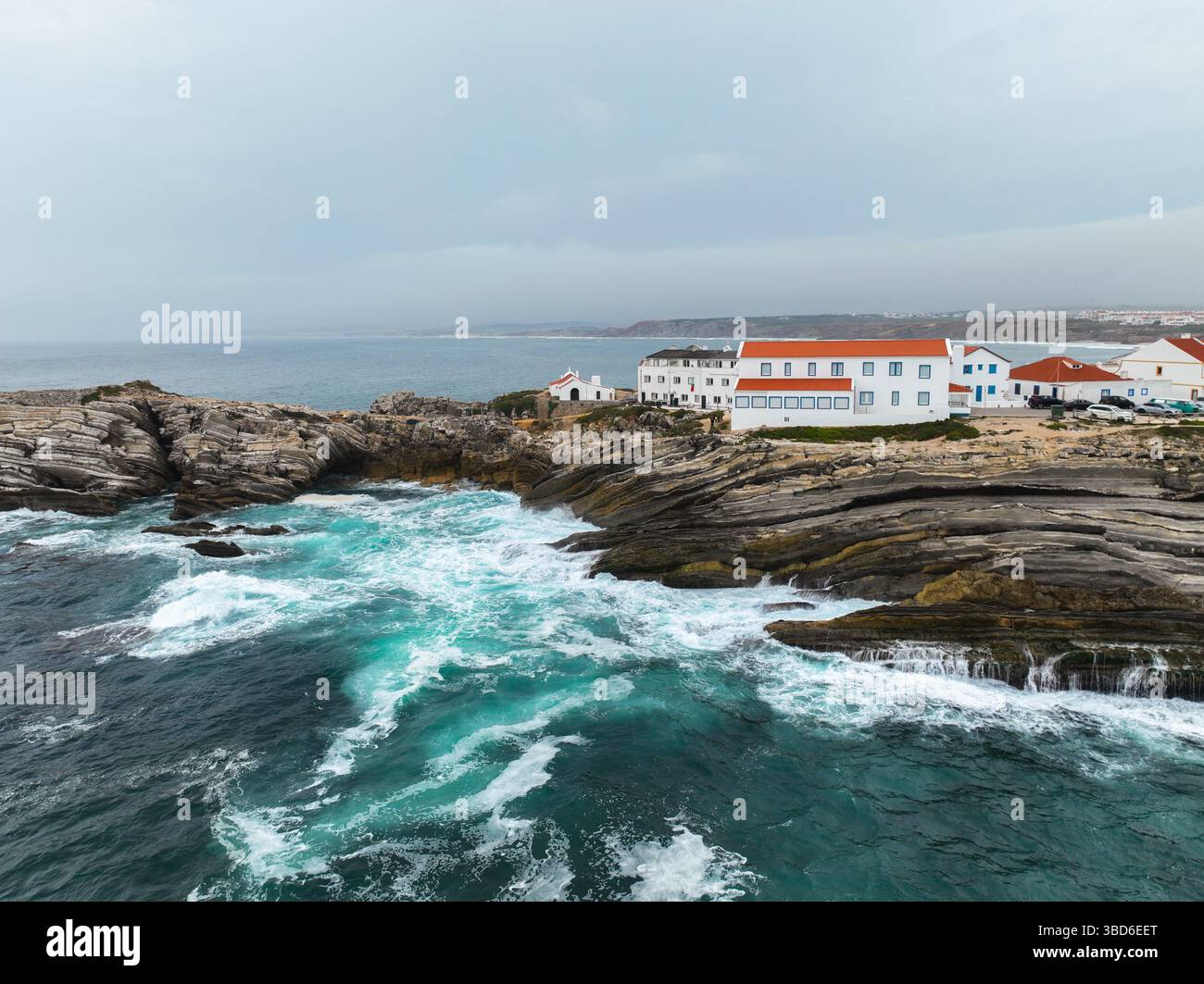 Oceanfront Rocks Oceanfront shot of rock formations with buildings above foamy waves ...