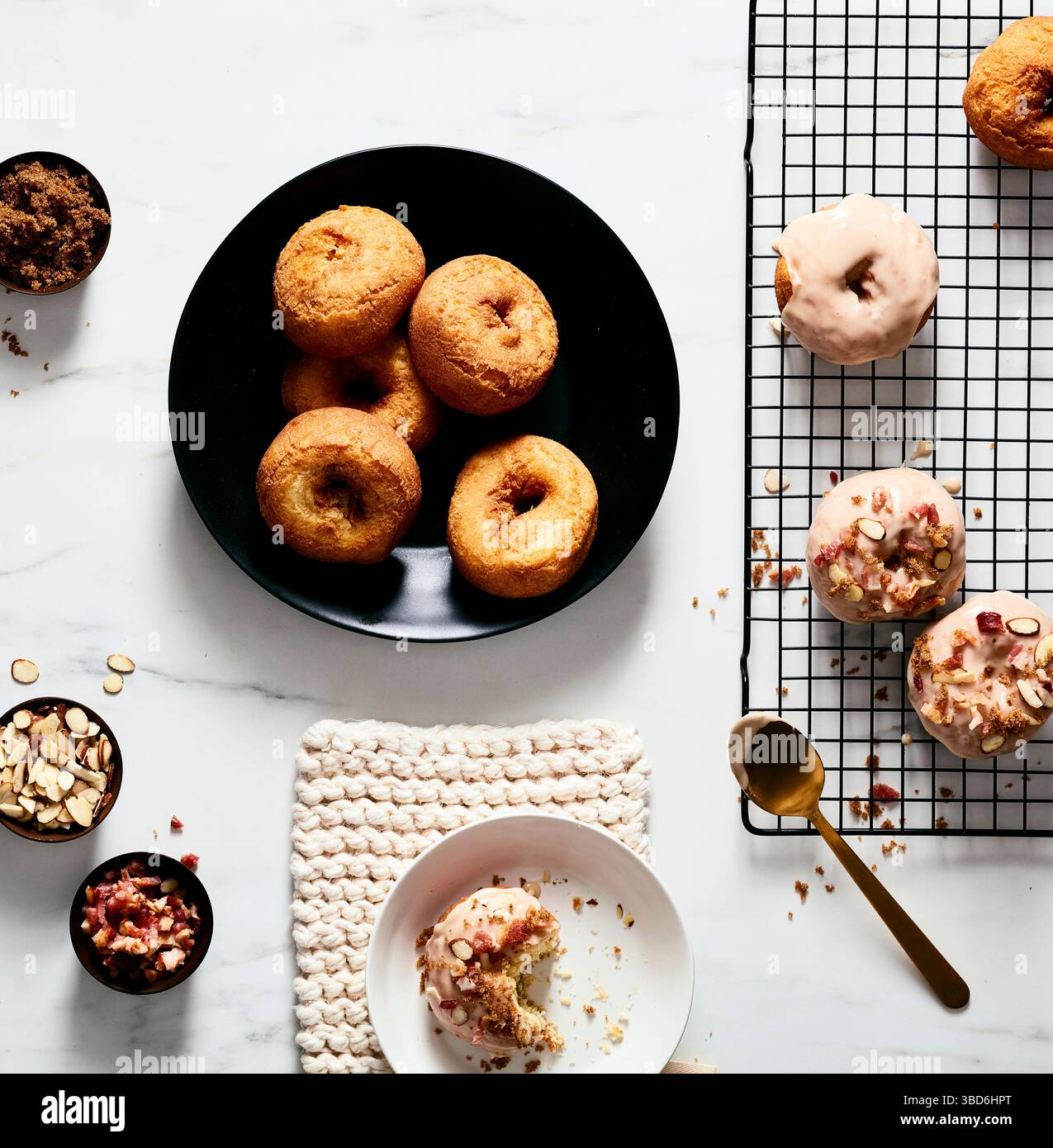 Plain and glazed donuts styled with toppings on white surface Stock Photo