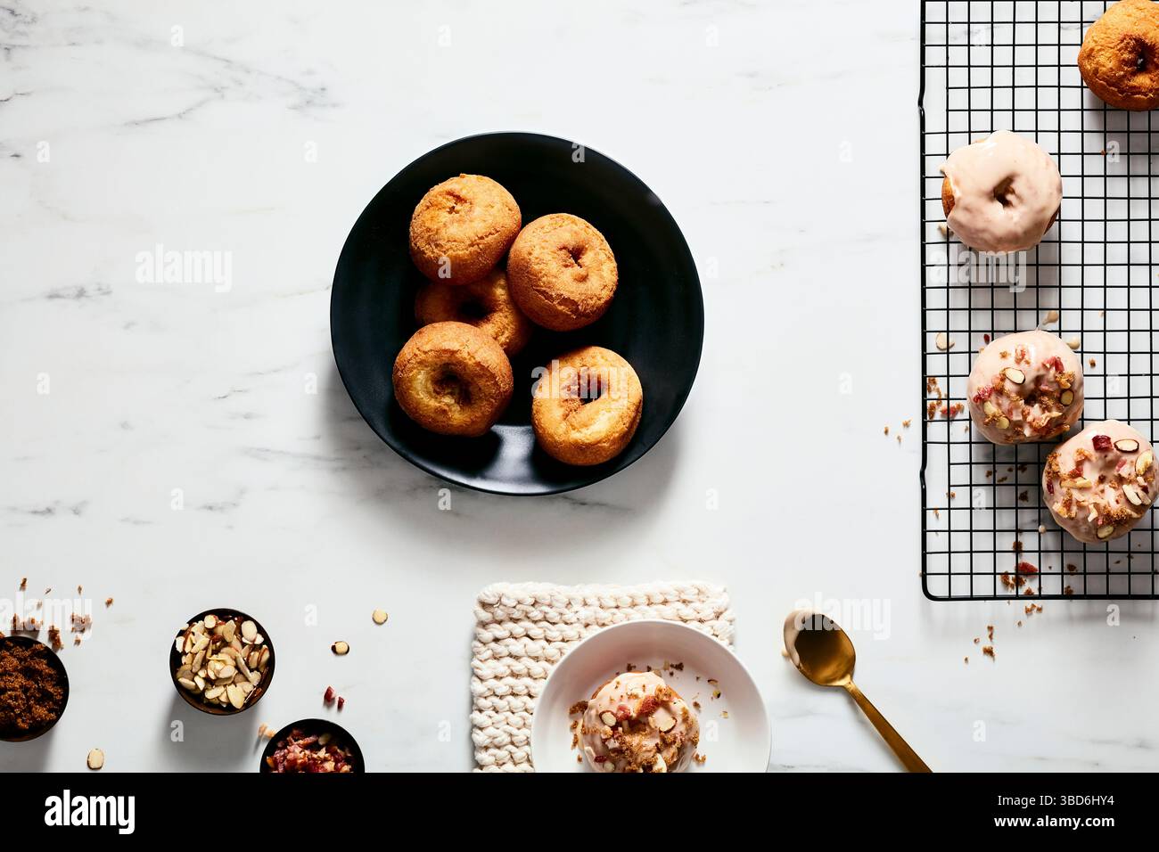 Plain and glazed donuts styled with toppings on white surface Stock Photo