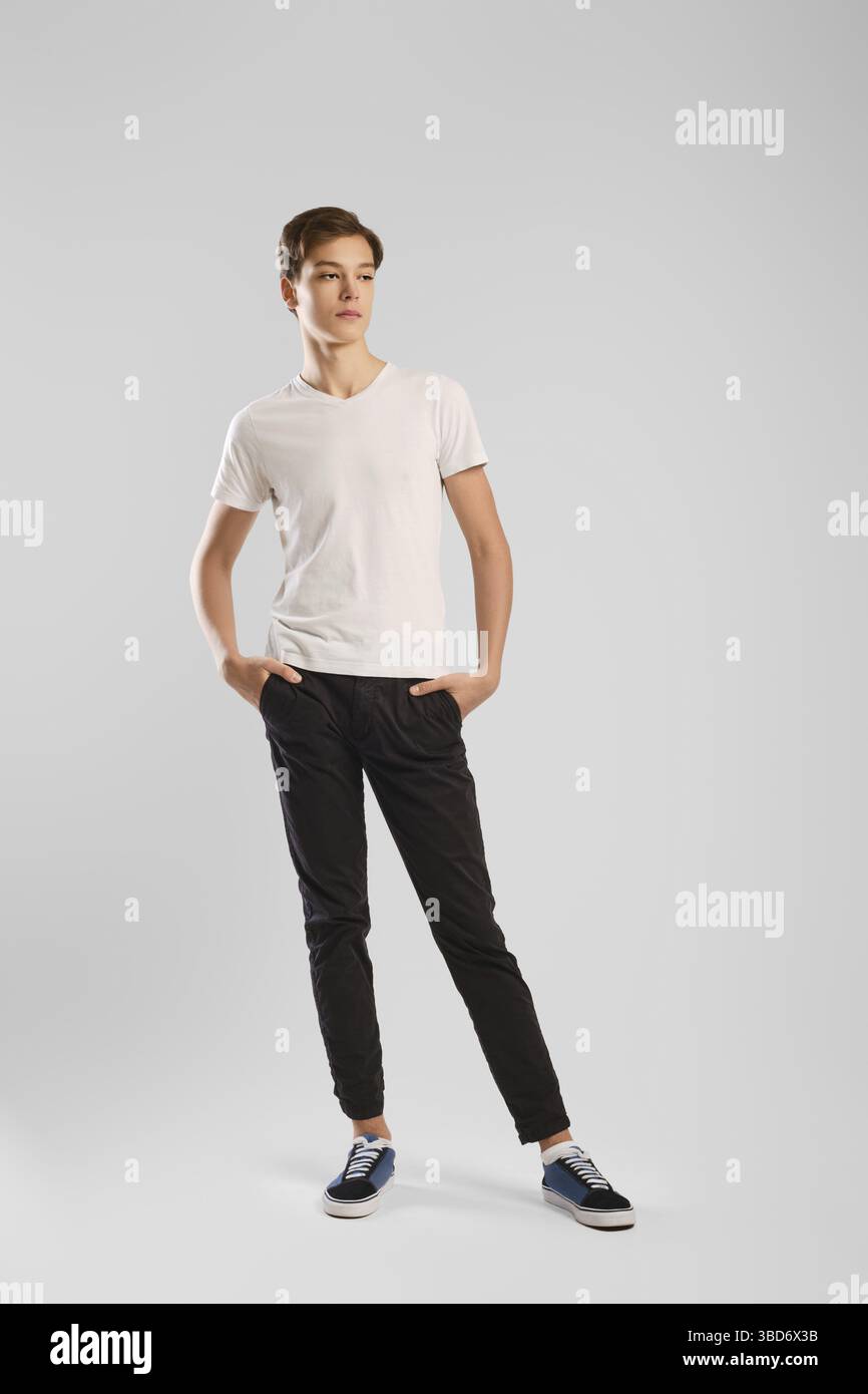 Young handsome man in black trousers and white shirt posing in studio Stock Photo