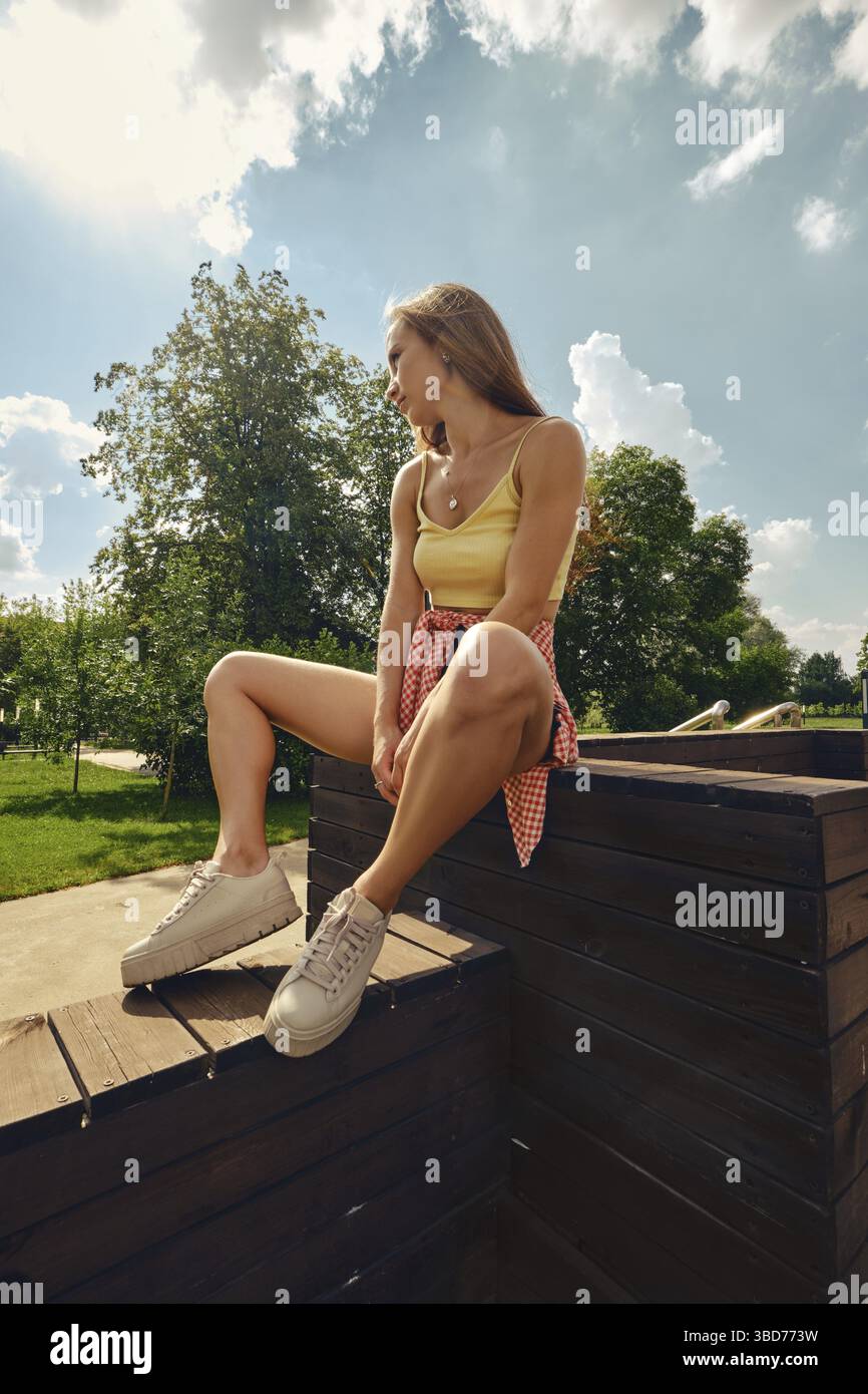 Young pretty woman sits on wooden flooring Stock Photo