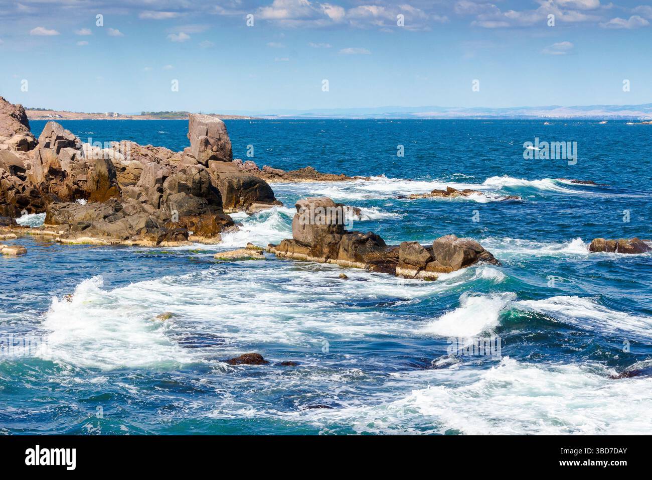 wave splashes on rocks at the black sea coast. summer vacations in europe. sozopol is a popular local travel destination of bulgaria. sunny day with b Stock Photo