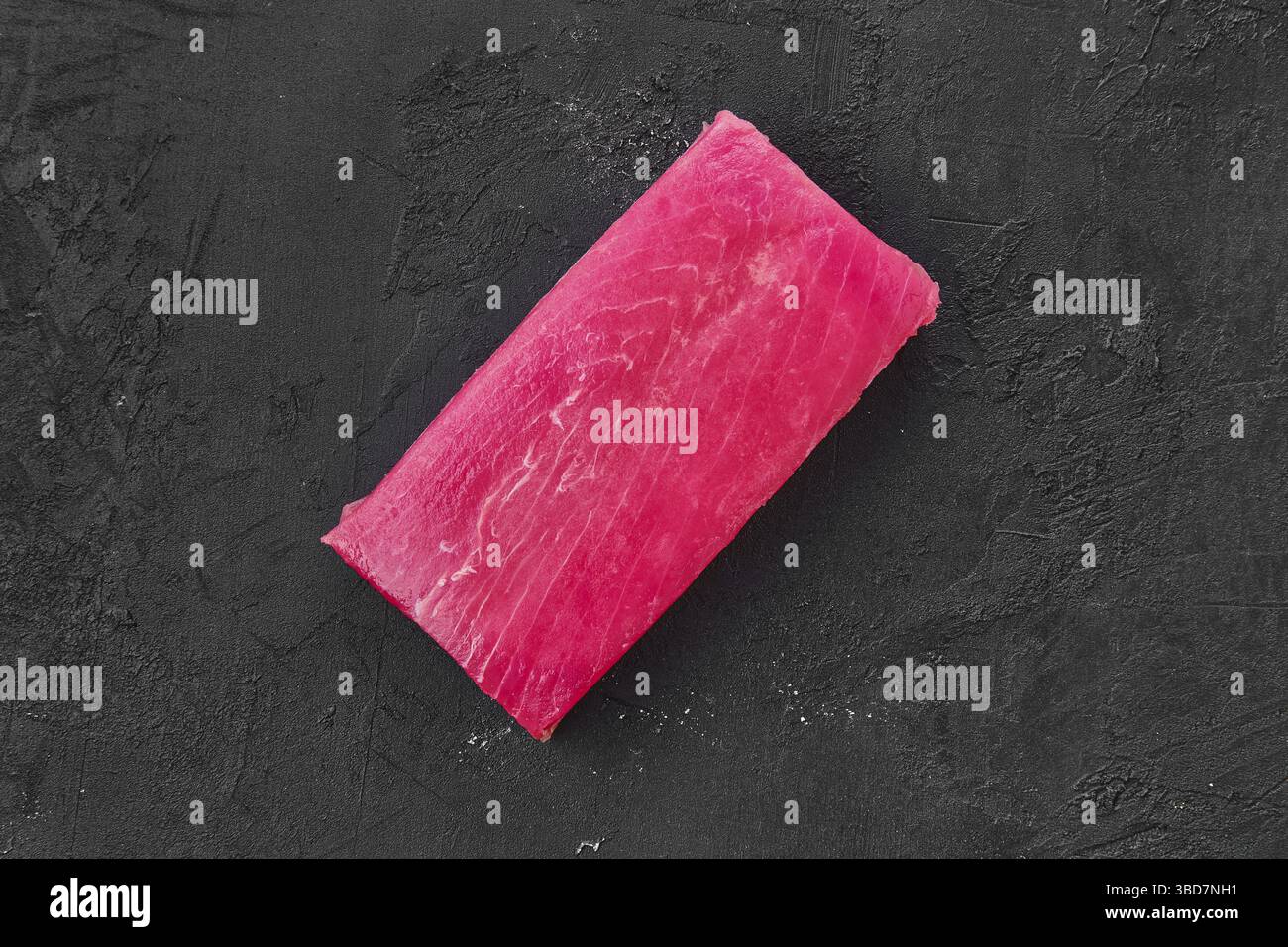 Raw frozen tuna fillet on black background Stock Photo