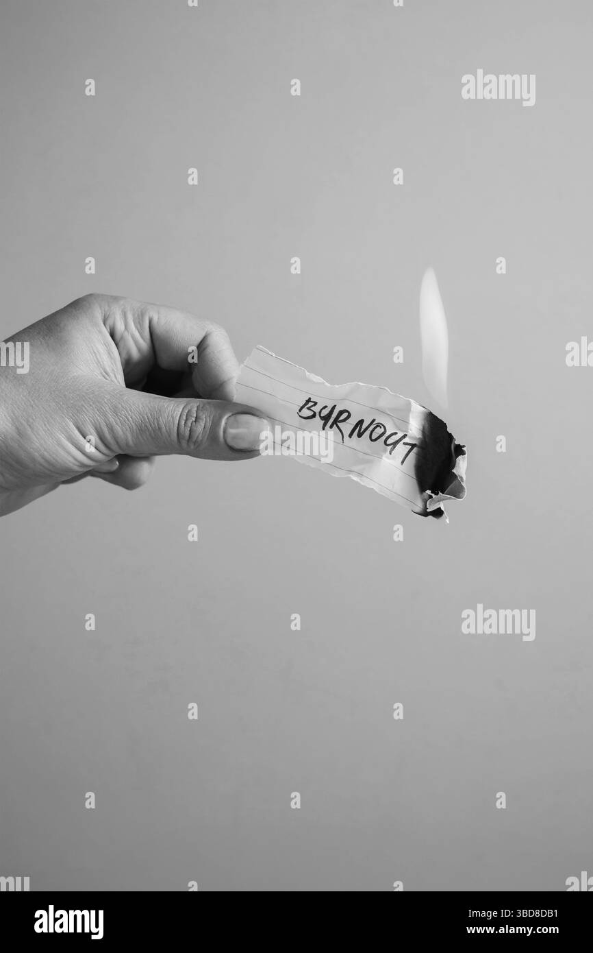 Burnout concept, hand holding a burning paper Stock Photo