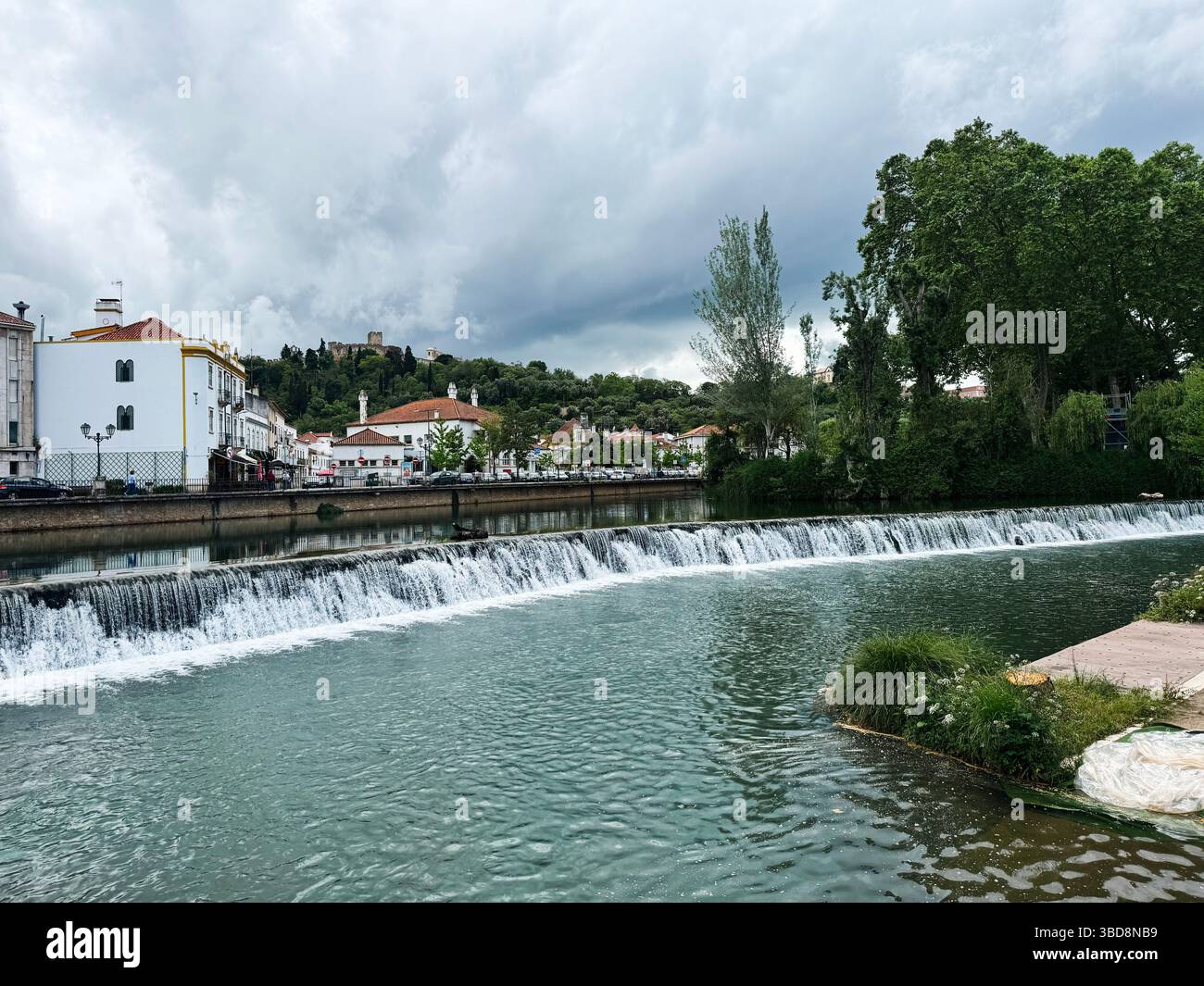 Scenic riverside with cascading waterfall and lush surroundings in ...