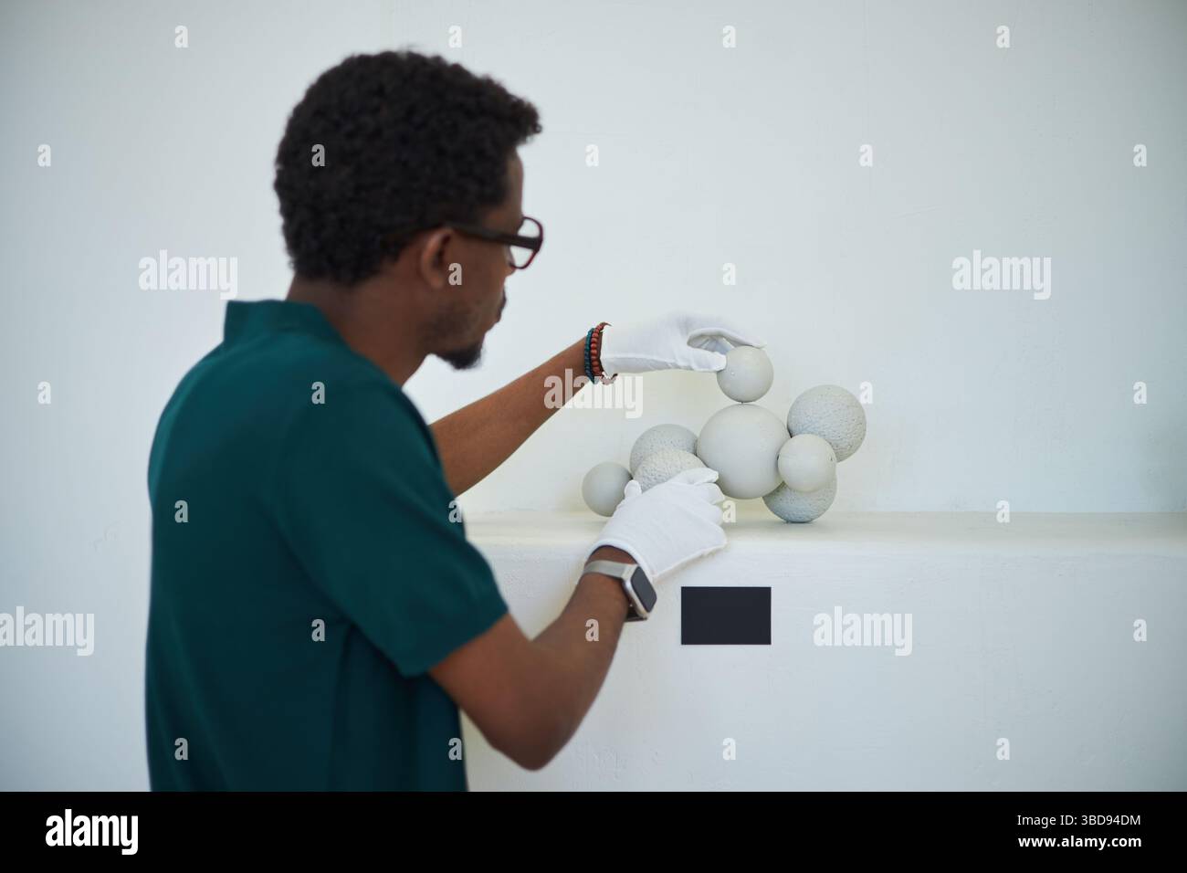 Art Curator With Glasses And Gloves Examining Modern Spherical art-curator-with-glasses-and-gloves-examining-modern-spherical