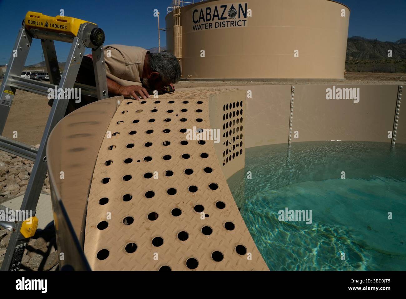 Glenn Chavez tests a newly installed Heli-Hydrant, a small, open tank ...