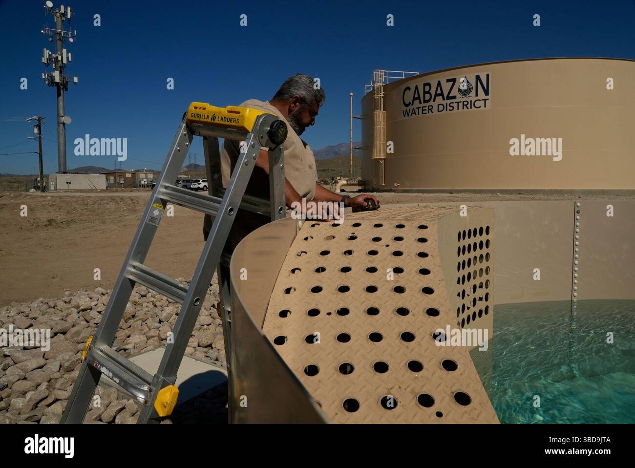 Glenn Chavez tests a newly installed Heli-Hydrant, a small, open tank ...