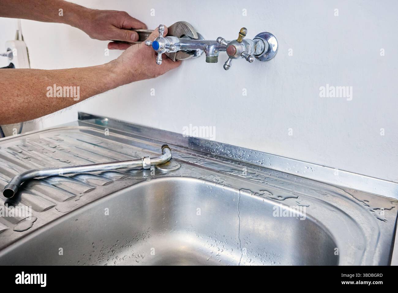 Removing old kitchen faucet for replacement with new one, person uses ...