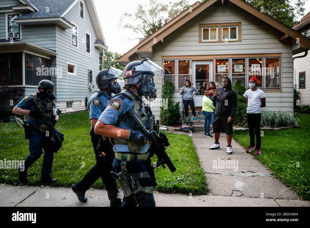 Protest Street Riot Protesters and residents watch as police in riot gear walk down a ...