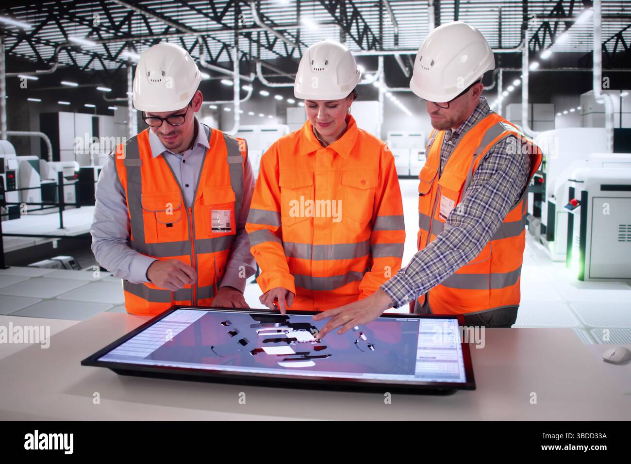 Automotive Engineers Collaborate On Electric Vehicle Design At Manufacturing Plant. Stock Photo