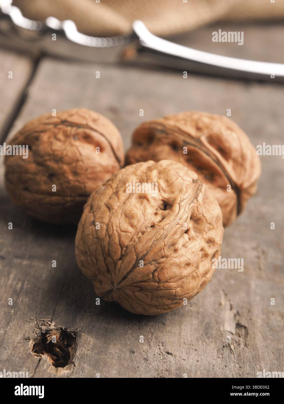 Three walnuts on a wooden table, close up shot Stock Photo