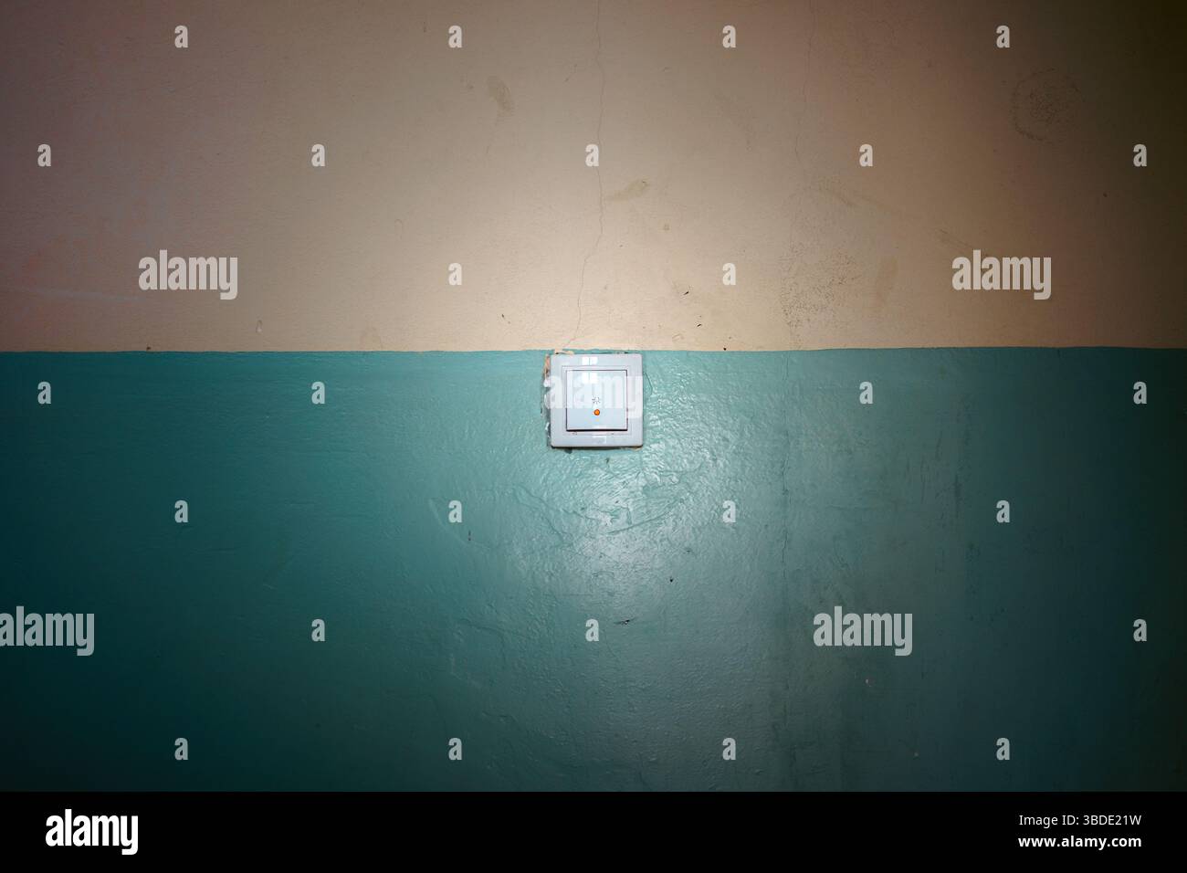 Details of the old wall in the lobby of the building with a light switch in the middle. Stock Photo
