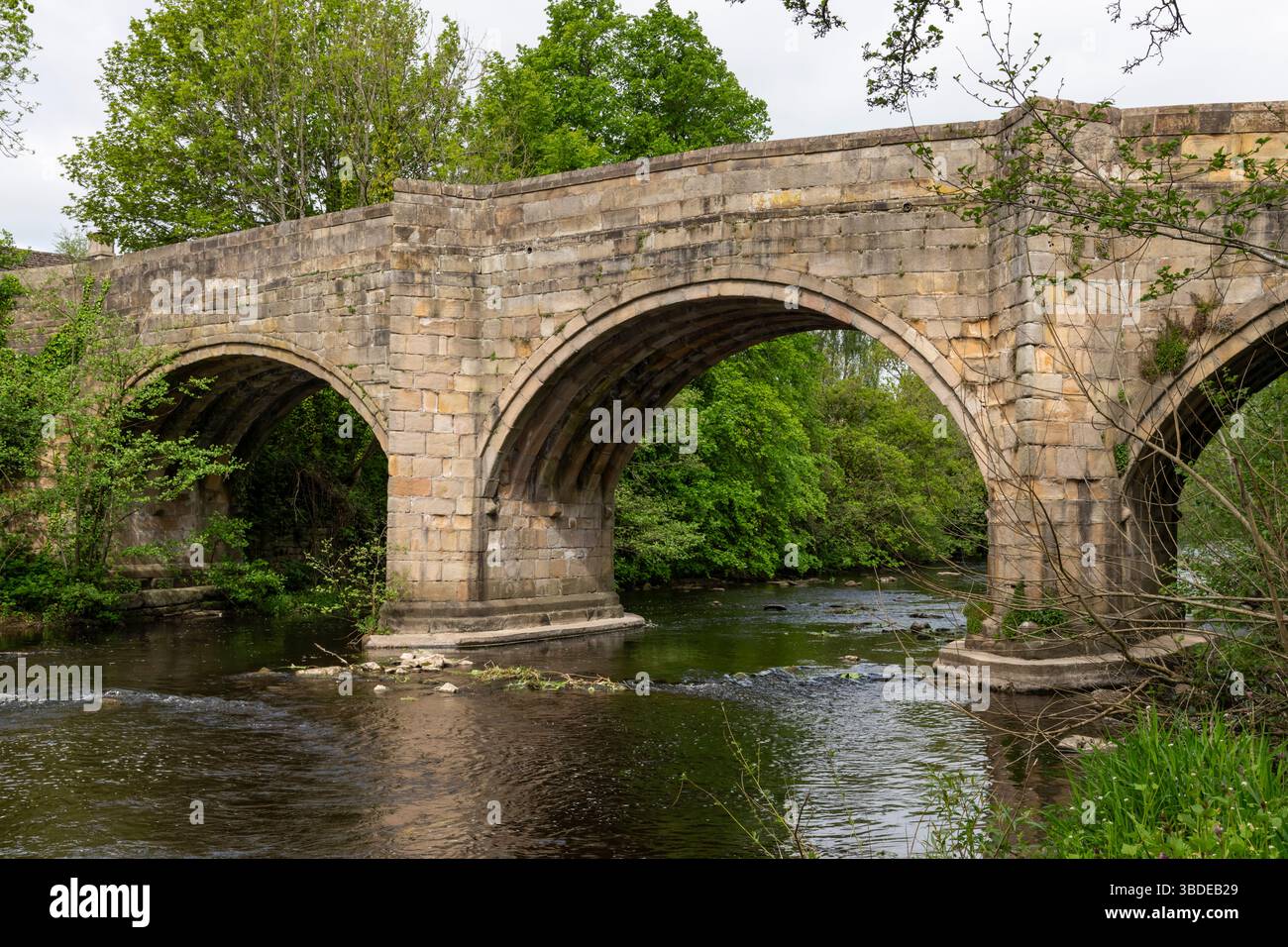 Old stone bridge over the river Derwent in the village of Baslow in the ...