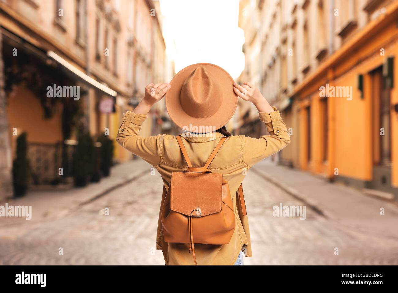 Tourist with backpack on city street, back view Stock Photo - Alamy