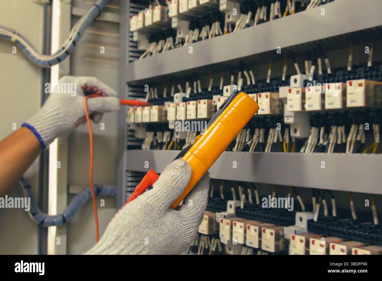 Technicians use multimeter to test or diagnose electrical control devices. Stock Photo