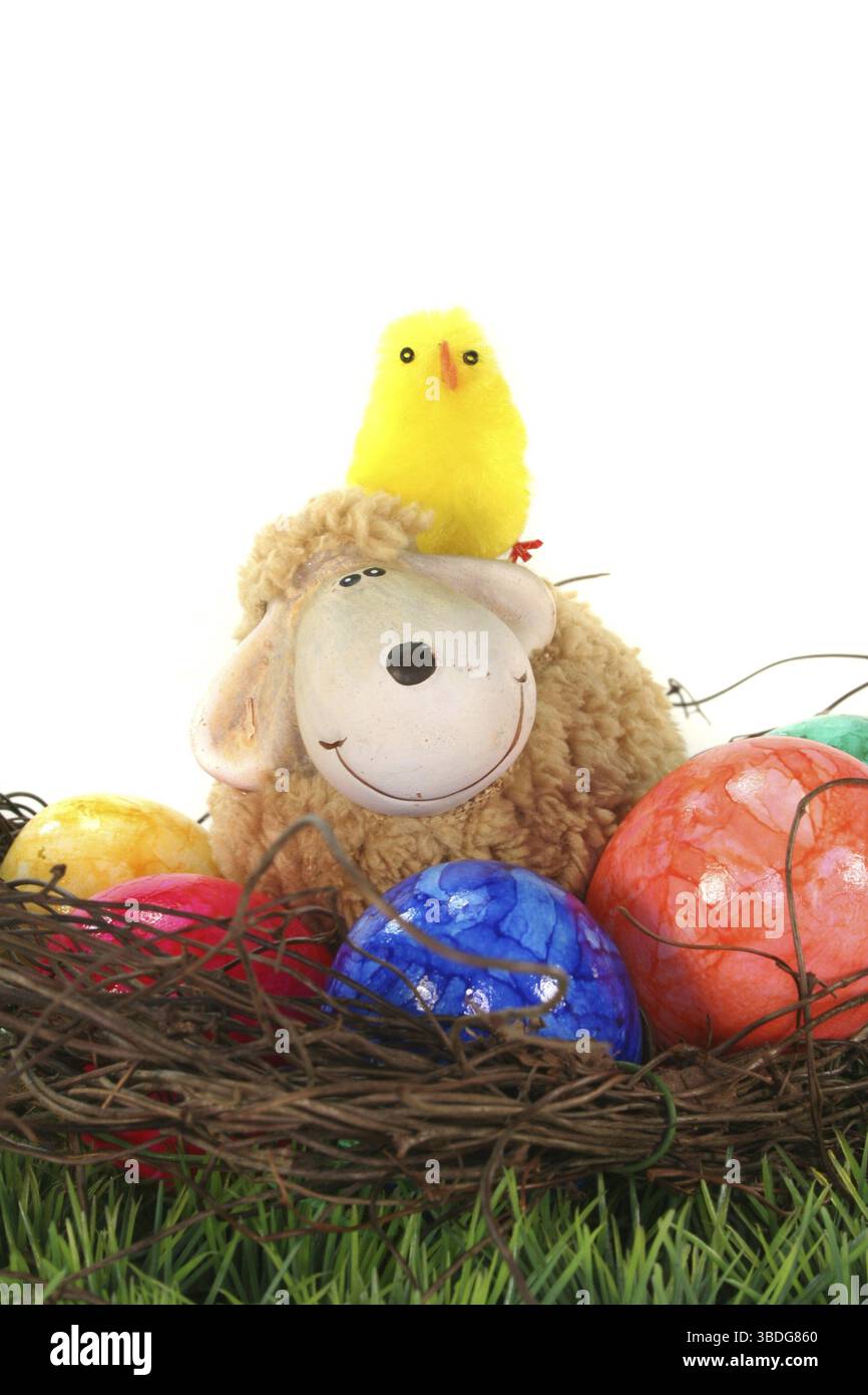 Easter nest with Easter eggs, sheep and chicks on a green flower meadow Stock Photo