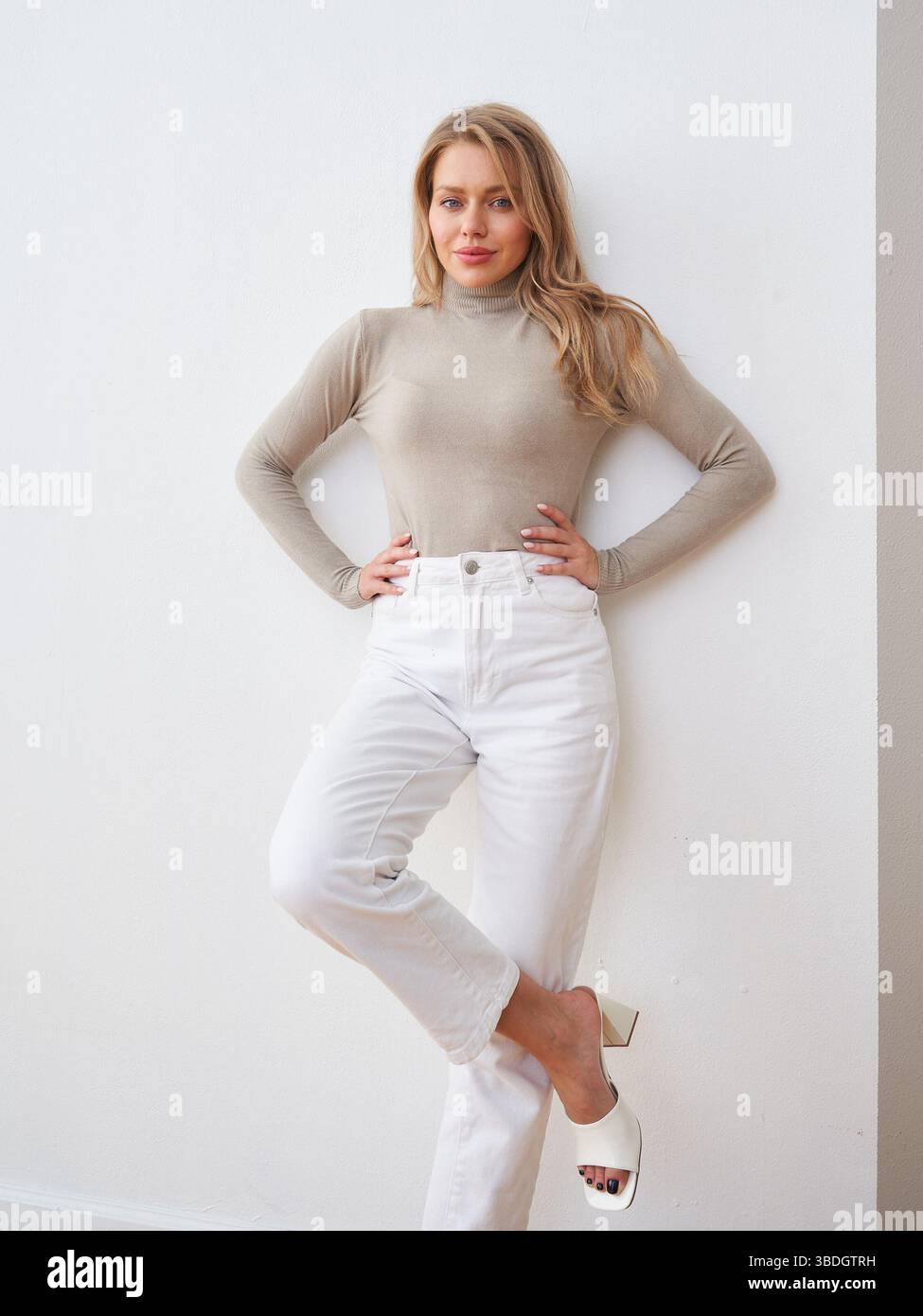 Stylish woman poses elegantly in a minimalist studio setting with a ...