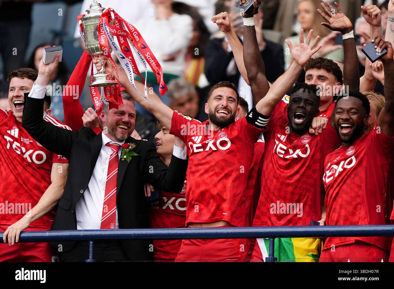 Aberdeen's Graeme Shinnie (centre) lifts the trophy after winning the ...