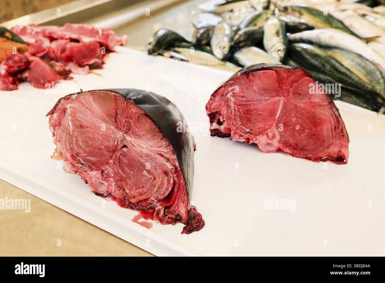 Parts of chopped red tuna fishes on the counter at market Stock Photo