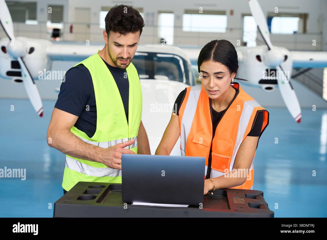 Aircraft mechanics using laptop for maintenance in hangar Stock Photo
