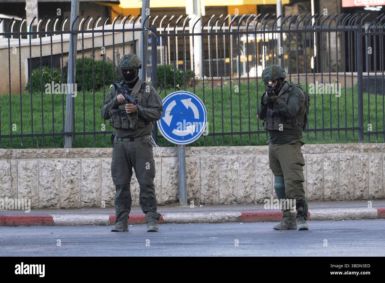 Israeli soldiers stand guard during a military raid in the Palestinians ...