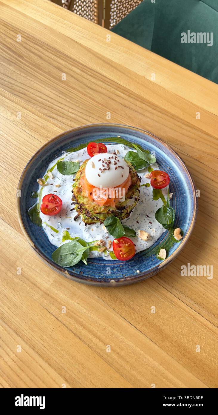 Zucchini fritters, red fish, salmon, poached egg. A restaurant dish. - Smartphone Captured Stock Image