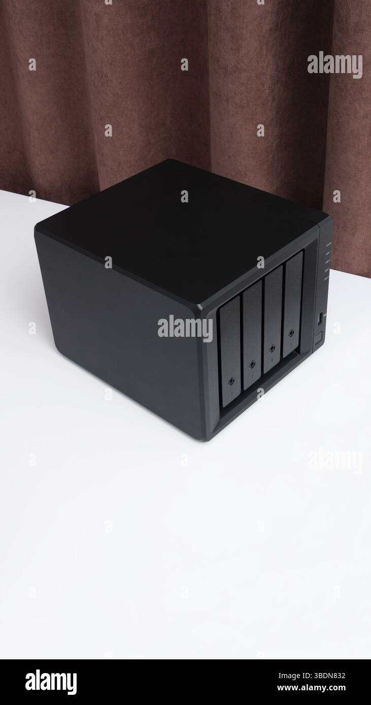 NAS server. Network storage. Device for backing up data on a white table in the room. Place for text. Stock Photo