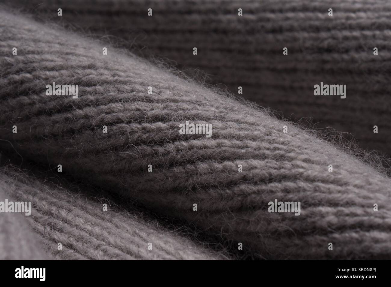 Gray woolen knitted scarf. View texture, close-up macro. Stock Photo