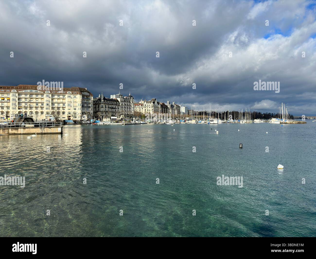 Geneva cityscape showcases Lake Geneva, stunning architecture, and cloudy skies. - Smartphone Captured Stock Image