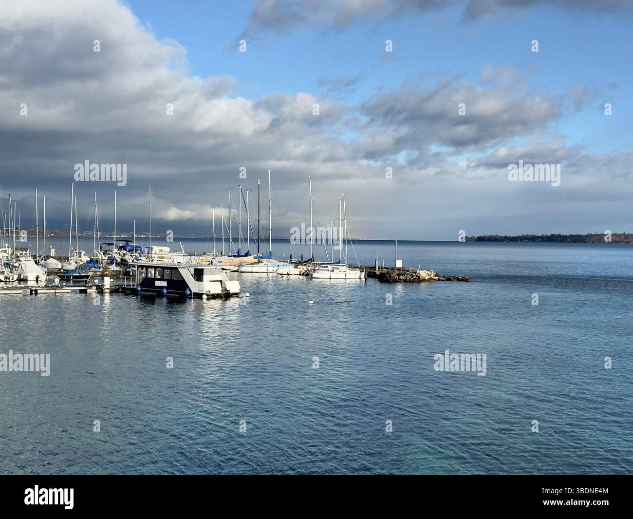 A peaceful harbor scene Geneva with boats docked under a bright blue and cloudy sky, perfect for a sunny day. - Smartphone Captured Stock Image