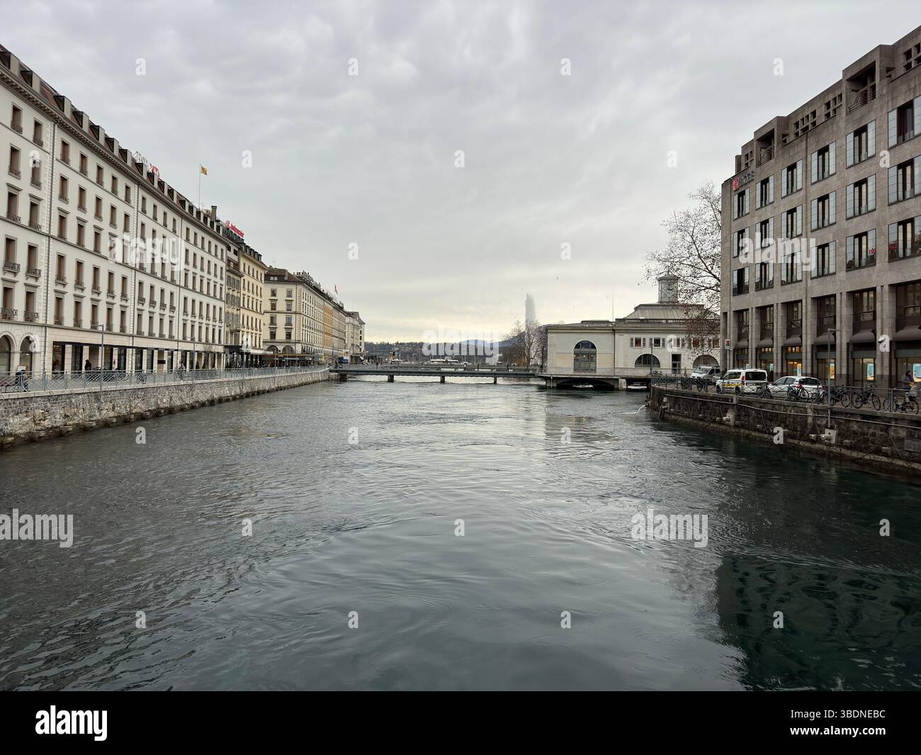 A picturesque view of a river flowing through the city of Geneva, Switzerland. - Smartphone Captured Stock Image