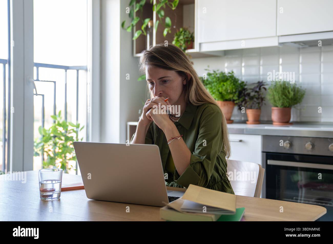 Focused thoughtful woman with laptop deep in process of solving tasks problems remote work IT field. Stock Photo