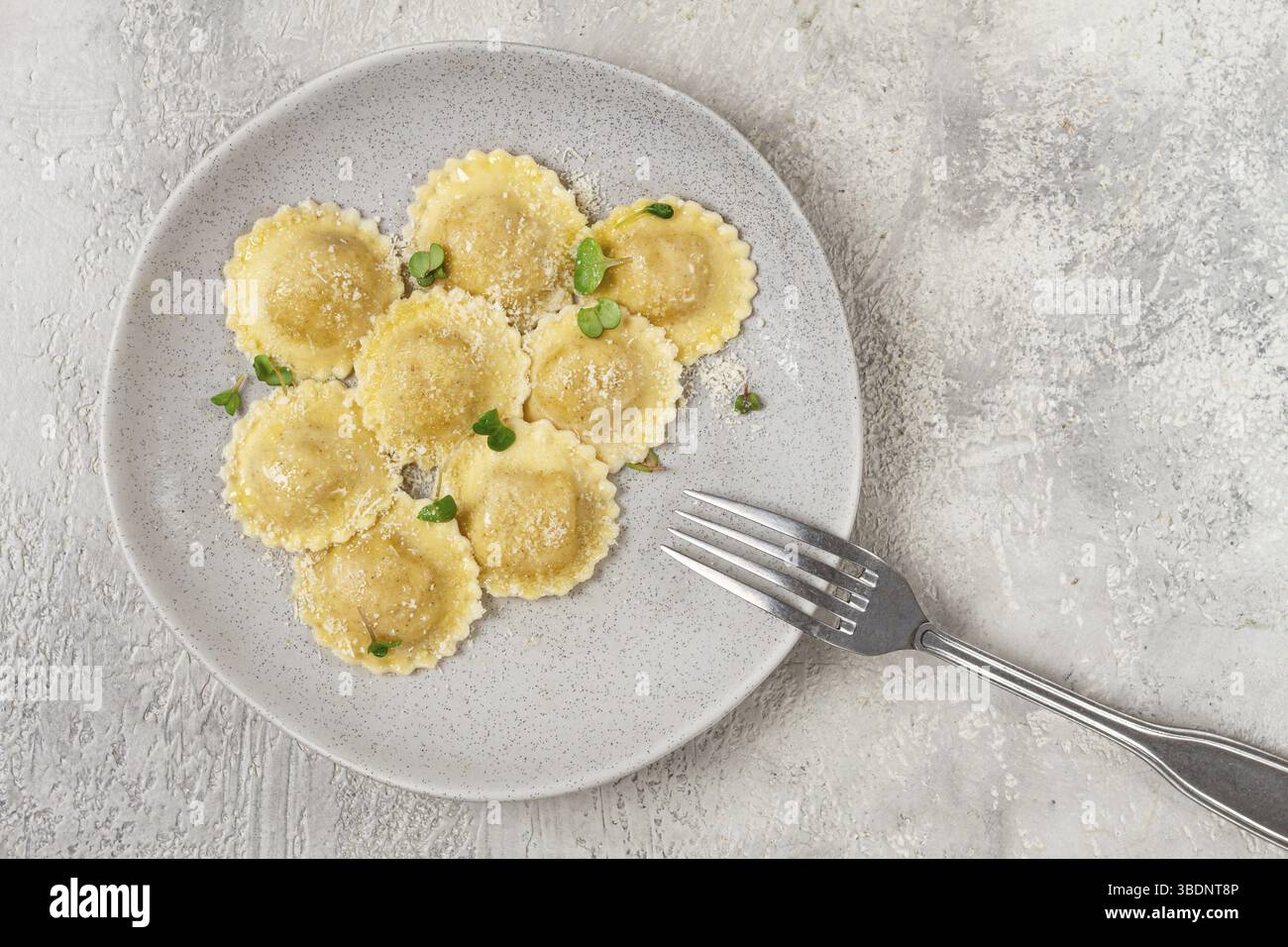 Fresh, ravioli with cheese, and microgreens, on a light plate, top view ...
