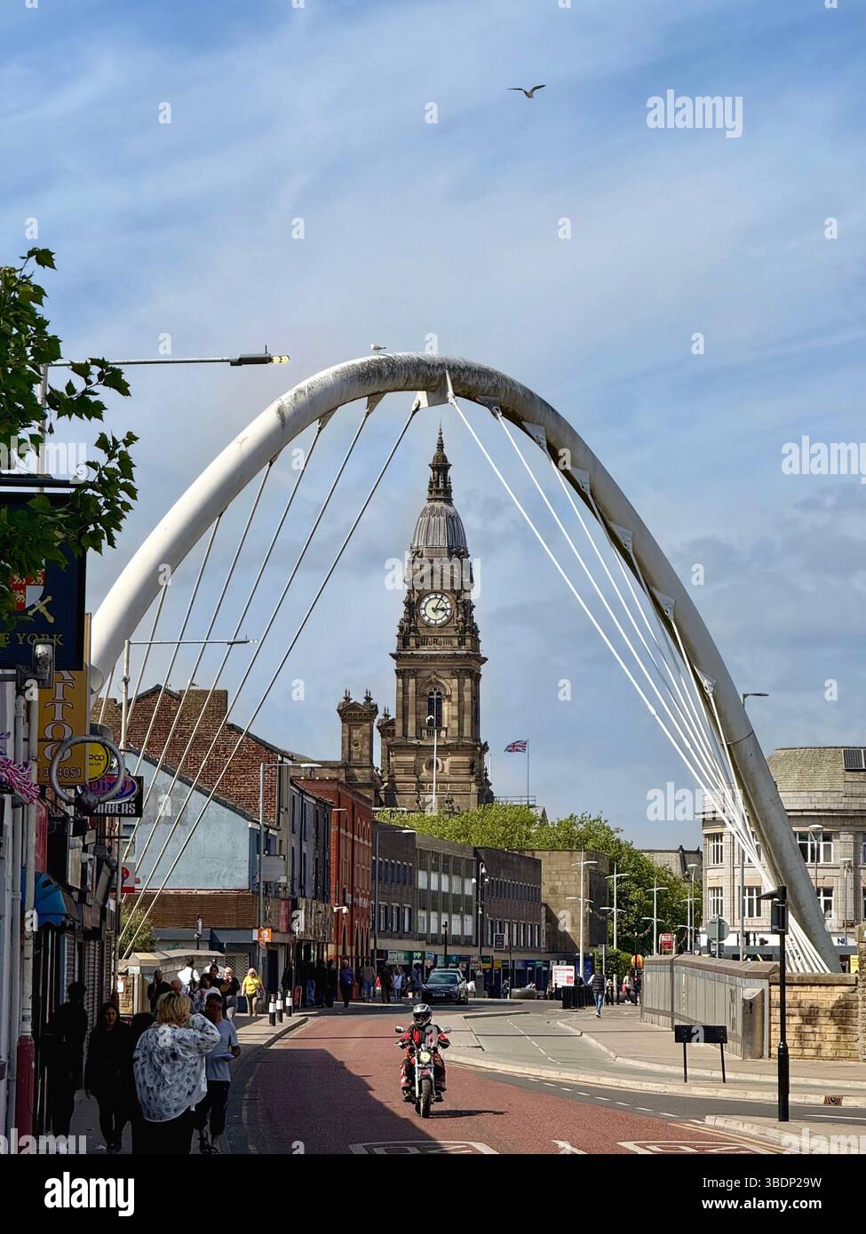 Clock tower of Bolton town halls framed by suspension bridge on Newport Street in Bolton town centre - Smartphone Captured Stock Image