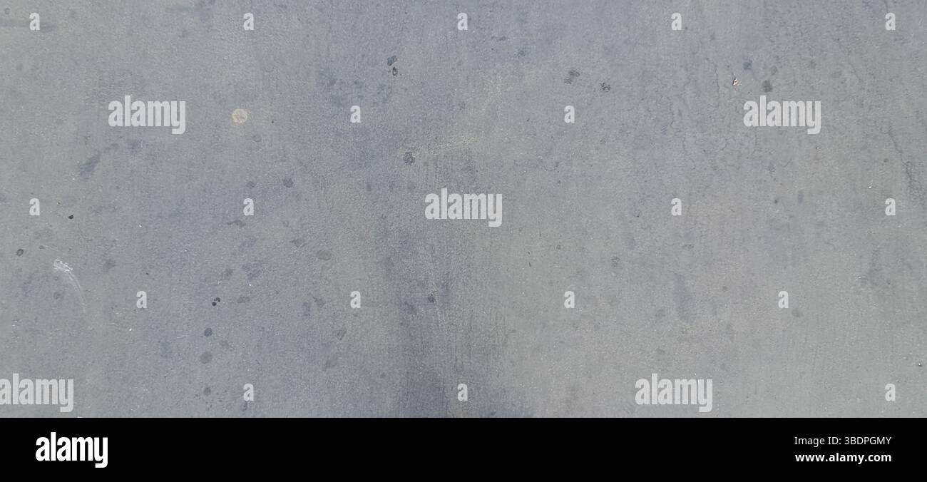 Close-up of a gray concrete surface featuring various small spots and textures Stock Photo