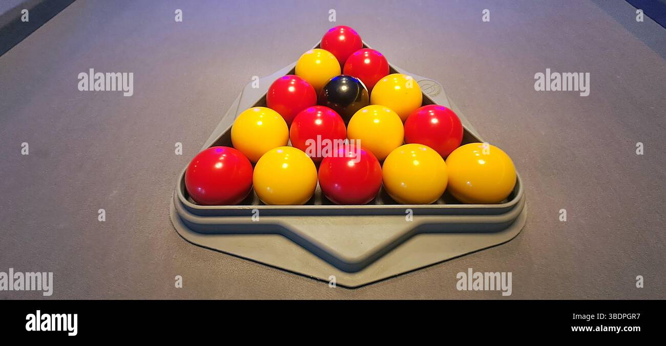Colorful pool balls arranged in a triangle on a pool table, awaiting ...