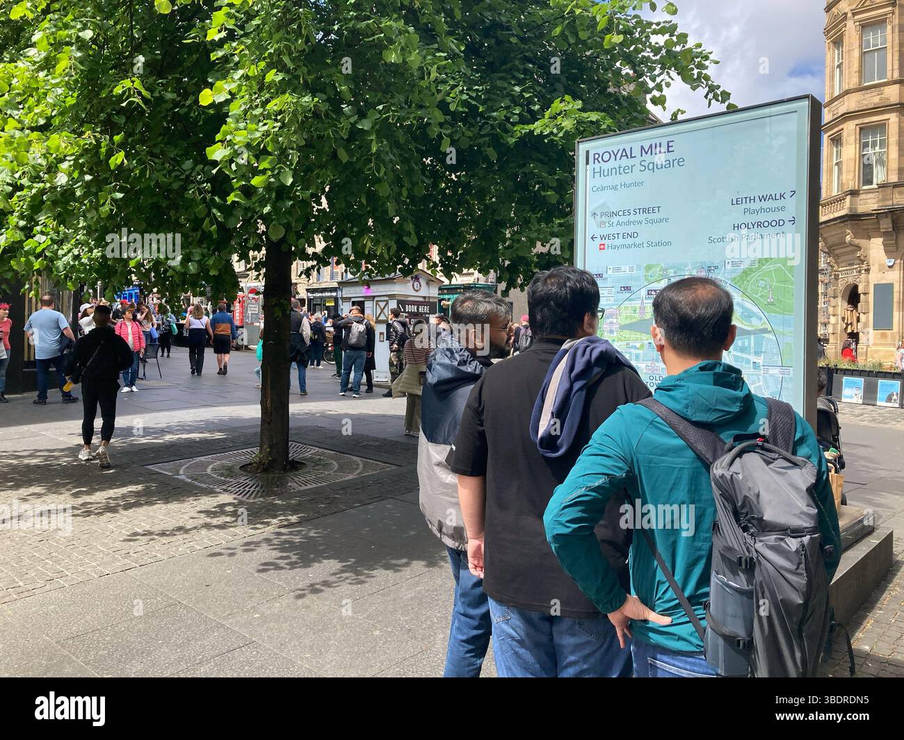 Visitors at information board with city map and attractions on Hunter Square and Royal Mile, Edinburgh Scotland - Smartphone Captured Stock Image