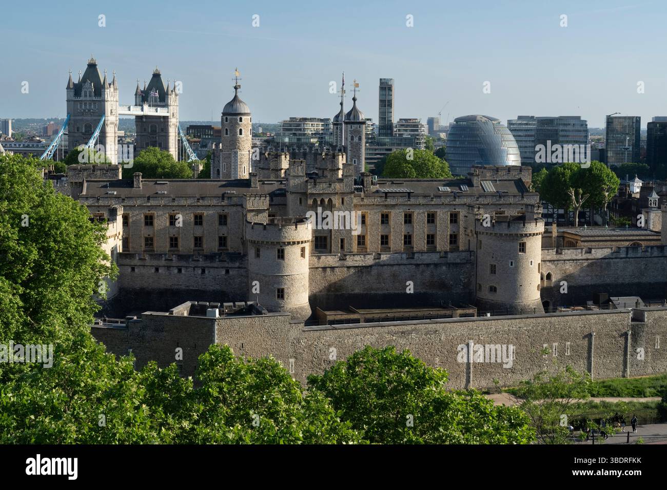 A view of the Tower of London, a historic castle in central London, UK, with Tower Bridge in the background. Tourists visit to explore its history. Stock Photo