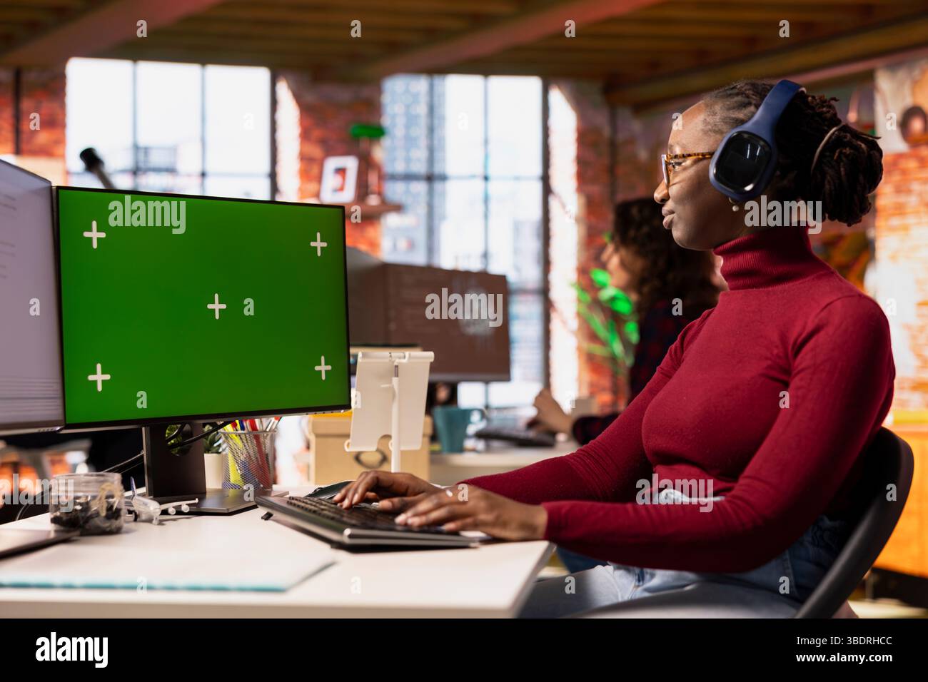 Programmer coding in startup office using isolated screen PC, listening ...