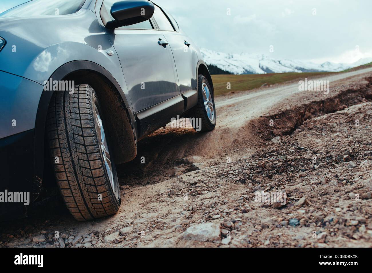 Car driving on bumpy road after landslide in the mountains Stock Photo